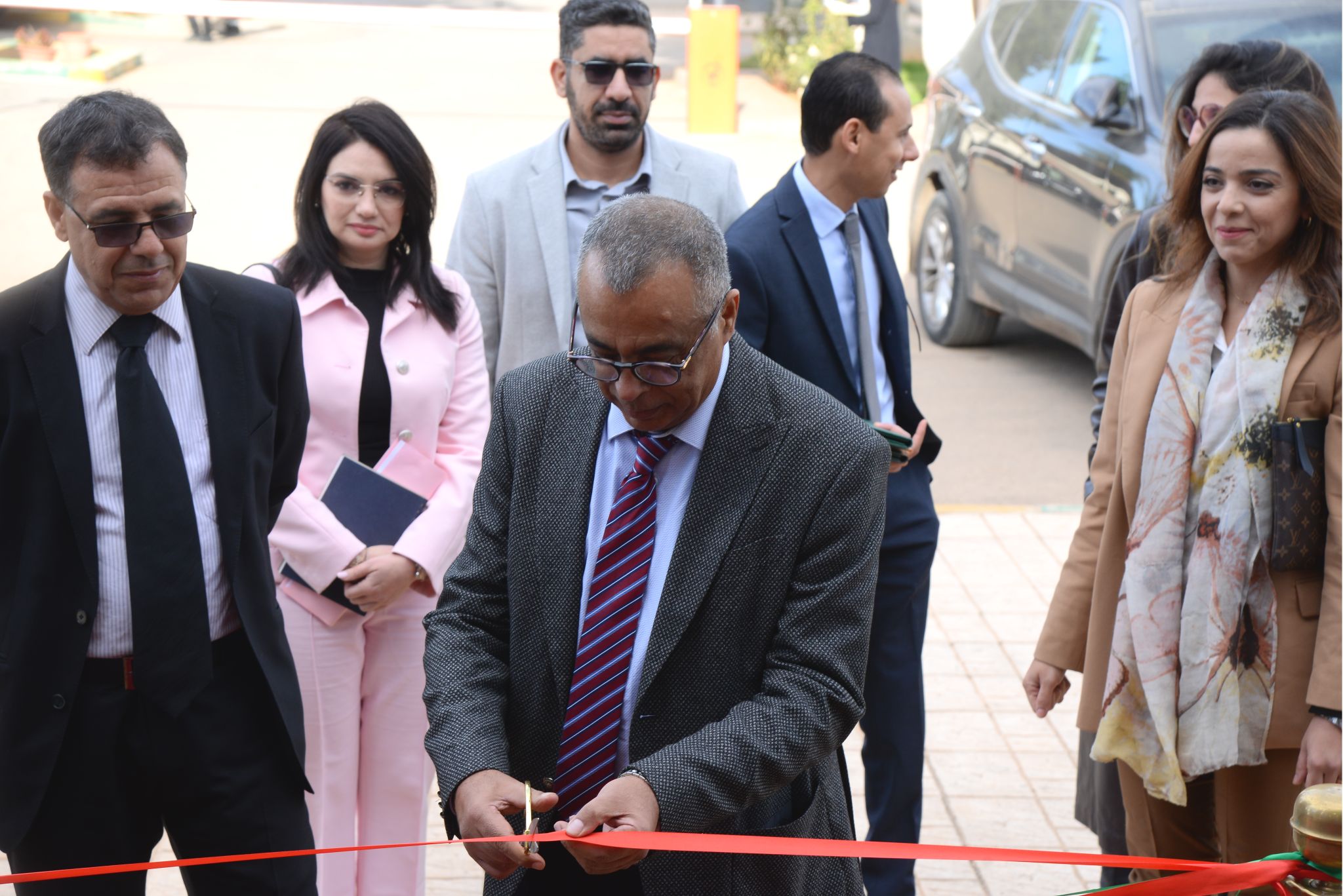 The Dean of ENCG Meknès cutting a ceremonial ribbon to inaugurate an academic or institutional event.